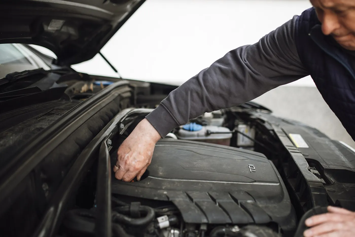 Mechanic working on a car engine in a garage