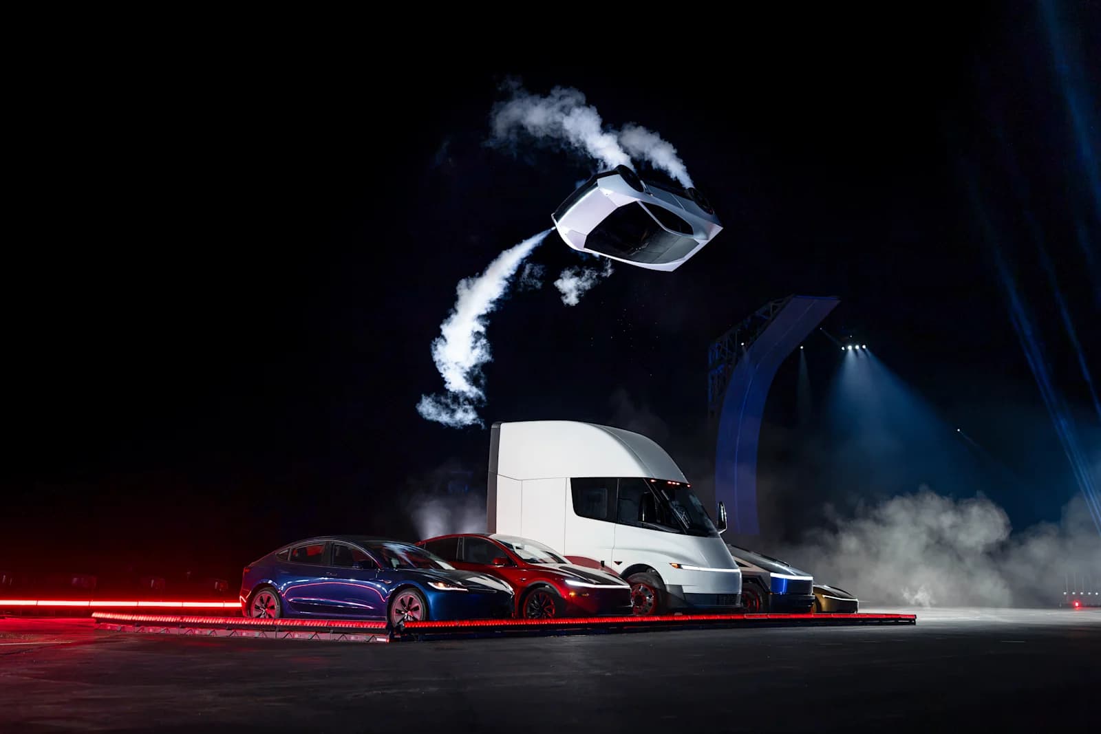 Tesla Roadster airborne above other Tesla vehicles at the October 2026 reveal